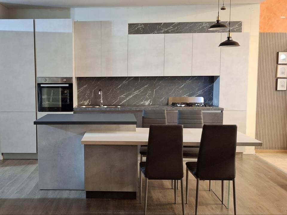 Кухня Stosa Cucine со светлыми рамочными фасадами и островом в экспозиции фабрики