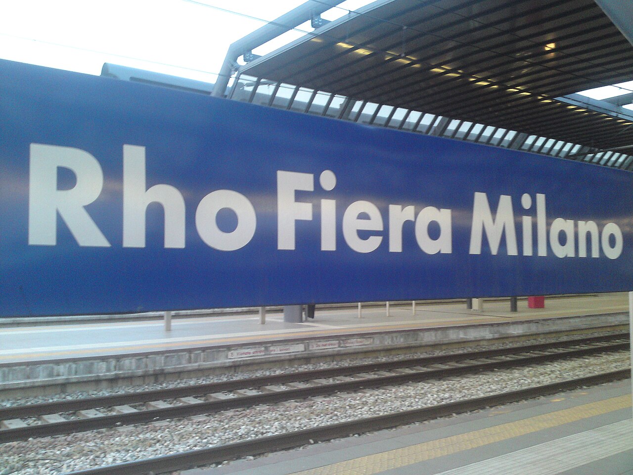 Табличка станции Rho Fiera Milano на перроне Trenord
